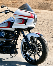 A white and red Harley Davidson motorcycle parked on pavement with RWD V-Twin fender installed